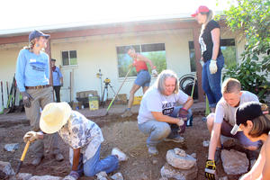 Co-op workshop attendees create passive and active rainwater harvesting systems at a home in the Palo Verde neighborhood on Aug 5, 2017. Here, they are working on digging basins that will passively capture rainwater, and will line the basins with rocks so the basins do not erode during a heavy rain. Photo: Jamie Manser/Watershed Management Group