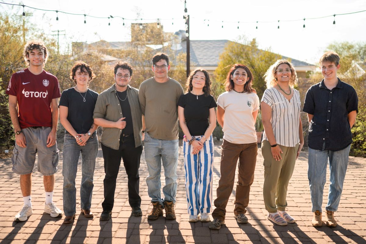 a group of eight interns, apprentices, and docents standing on the Living Lab patio