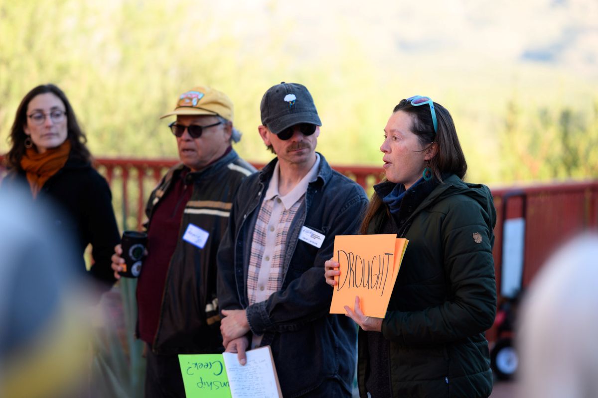Watershed staff hold speaking to a group and holding a sign that says drought