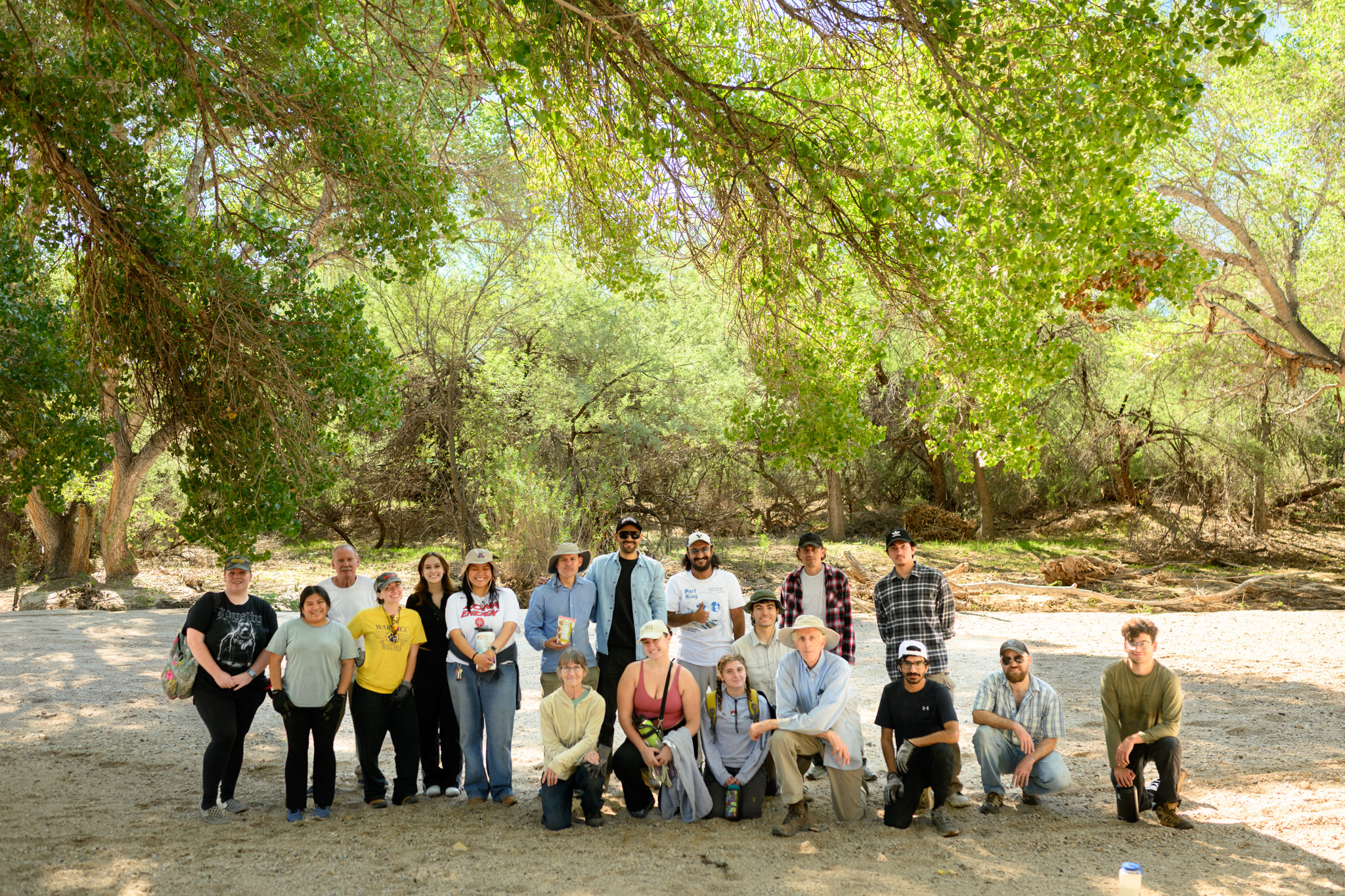 A group of staff and volunteers gathered and smiling after a busy morning of removing invasive Arundo
