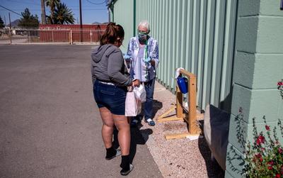Jean Fedigan, executive director of the Sister Jose Women’s Shelter located at 1050 S. Park Ave., shows the “Tippy tap” hand wash station to a woman.