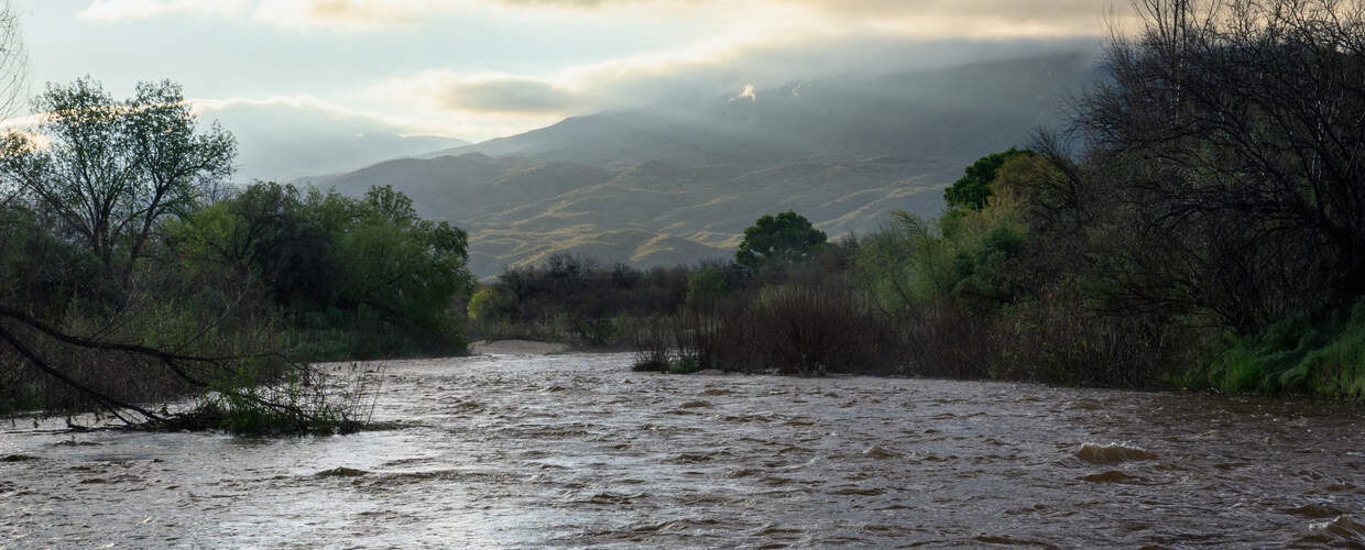 a wide river flows with mountains in the background
