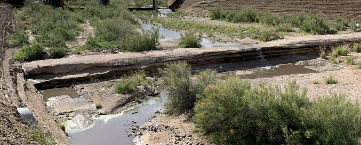 creek flowing through a spillway in a low dam
