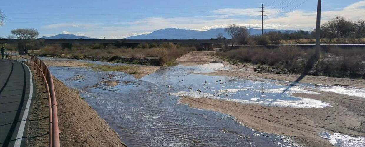 rapidly moving water in a river bed next to a path