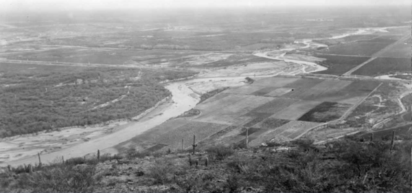 The Santa Cruz River in 1989, facing south toward the Santa Rita Mountains. In place of the mesquite bosque from 1942, there is a dry river bed with little to no vegetation. Photo credit: U.S. Geological Survey.