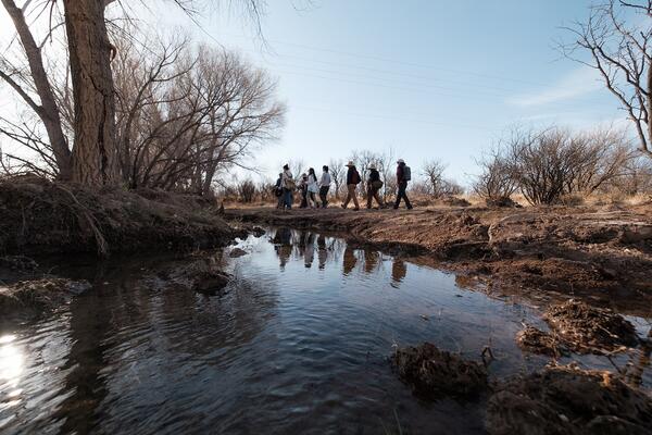 a group of people walking along cienega creek