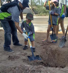 Child learning to use shovel