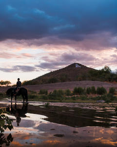 A rider and his horse enjoy the Santa Cruz River at dusk. Photo by Julius Schlosburg