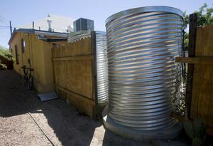 Gail Ryser, a Watershed Management Group co-op participant, helped install a water-harvesting system in someone else's home and got help in installations of two cisterns in her backyard.