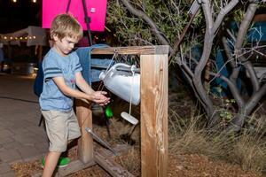 child washing hands at the tippytap 