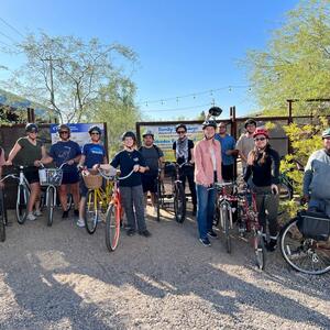 diverse group of people with bikes outside the gates of the Living Lab