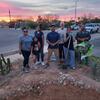 a group of people smiling in front of a newly created rain garden