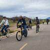 a group of bicyclists riding along a bike path in tucson
